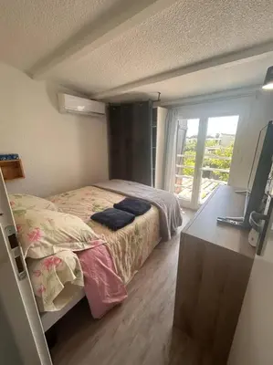 a bedroom with a bed and a desk with a television at Maison bord de mer in Poggio-Mezzana