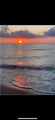 a sunset on the beach with the ocean at Maison bord de mer in Poggio-Mezzana