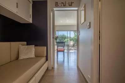 a hallway with a couch and a door leading to a patio at Appartement 4 étoiles piscine et plage à pied in Porto-Vecchio