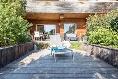 a patio with a white chair and a table at Appartement 4 étoiles piscine et plage à pied in Porto-Vecchio