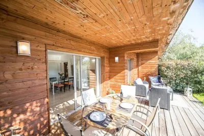 a wooden patio with a table and chairs on a deck at Appartement 4 étoiles piscine et plage à pied in Porto-Vecchio