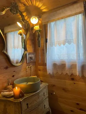 a bathroom with a sink and a mirror at Roulotte insolite U tragulinu in Zonza