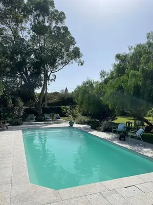 a large blue swimming pool in a yard at Location à Porto Vecchio in Porto-Vecchio