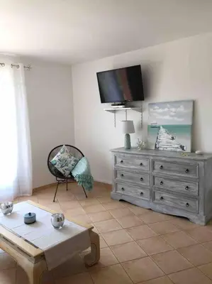 a living room with a tv on top of a dresser at Location à Porto Vecchio in Porto-Vecchio