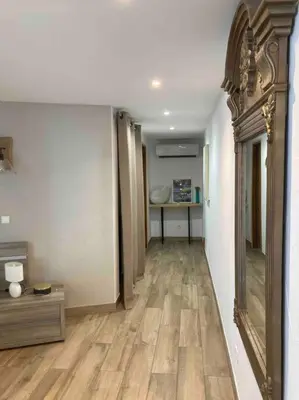 a room with a hallway with wooden floors and a mirror at Location à Porto Vecchio in Porto-Vecchio