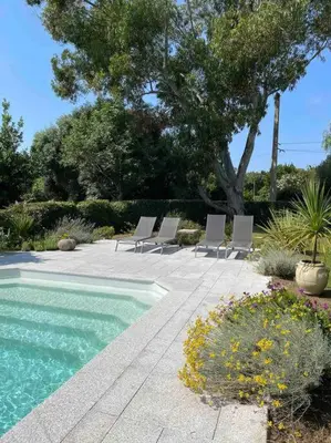 a group of chairs sitting next to a swimming pool at Location à Porto Vecchio in Porto-Vecchio
