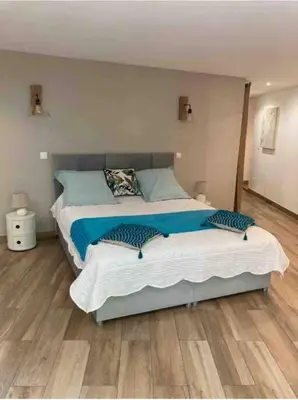 a bedroom with a large bed with blue pillows at Location à Porto Vecchio in Porto-Vecchio