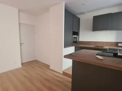 a kitchen with black cabinets and a wooden counter top at T2 centre ville Ajaccio in Ajaccio