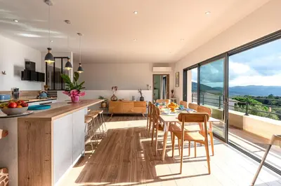 a kitchen and dining room with a table and chairs at Maison Altea - Maison climatisée in Figari