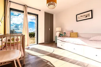 a bedroom with a bed and a window at Maison Altea - Maison climatisée in Figari