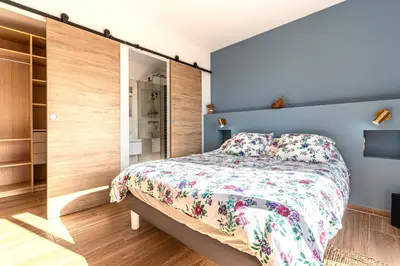 a bedroom with a bed with a floral bedspread at Maison Altea - Maison climatisée in Figari