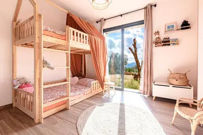 a bedroom with bunk beds and a large window at Maison Altea - Maison climatisée in Figari