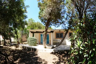 a house with trees in front of it at Village Naturiste La Chiappa in Porto-Vecchio