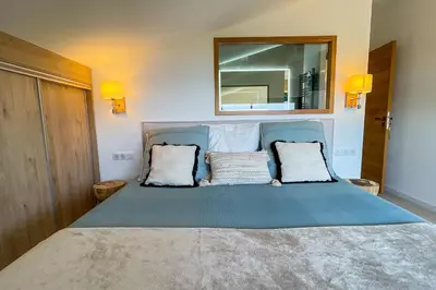 a bedroom with a large bed with a mirror on the wall at Villa San Ciprianu Mare Di Lecci in Lecci