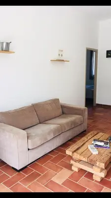a living room with a brown couch and a wooden table at A FATA DI L'ORTOLO gîtes à la ferme in Sartène