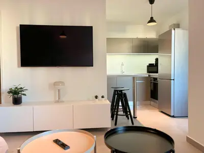 a living room with a tv on the wall at Charmant appartement à Ajaccio, proche de la mer ! in Ajaccio