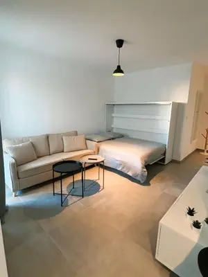a living room with a couch and a bed at Charmant appartement à Ajaccio, proche de la mer ! in Ajaccio