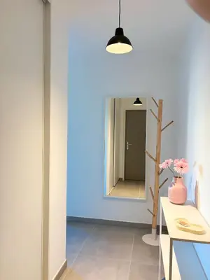 a hallway with a mirror and a vase of flowers at Charmant appartement à Ajaccio, proche de la mer ! in Ajaccio