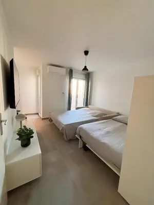 a bedroom with two beds and a television in it at Charmant appartement à Ajaccio, proche de la mer ! in Ajaccio