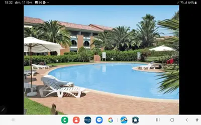 a large swimming pool with chairs and umbrellas at Doalchaléda in Linguizzetta