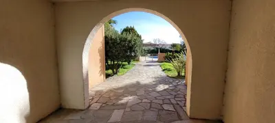 an archway in a building with a stone pathway at Doalchaléda in Linguizzetta