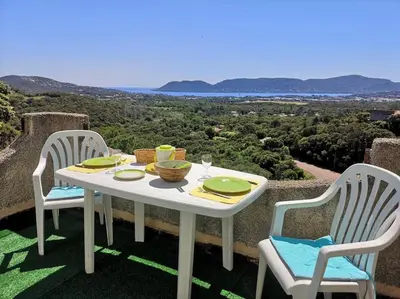 a white table with two chairs and a table with a view at La Tour dans haut de villa in Porto-Vecchio