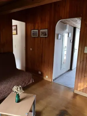 a bedroom with a bed and a table with a vase of flowers at La Tour dans haut de villa in Porto-Vecchio