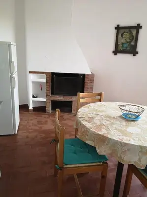 a kitchen with a table and chairs and a fireplace at La Tour dans haut de villa in Porto-Vecchio