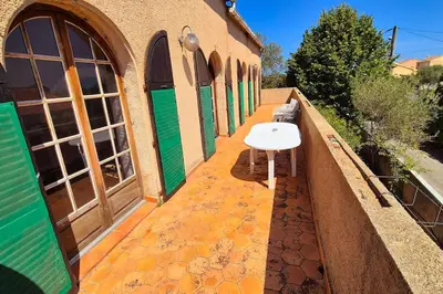 a building with green doors and a white sink on a sidewalk at T4 Furesta - Casa Mattea in Aléria