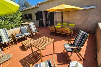 a patio with a table and chairs and an umbrella at T4 Furesta - Casa Mattea in Aléria