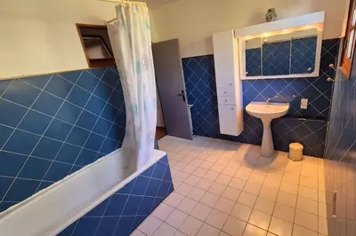 a blue tiled bathroom with a sink and a shower at T4 Furesta - Casa Mattea in Aléria