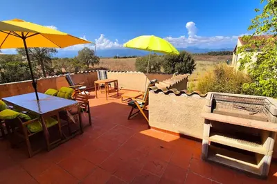 a patio with a table and yellow umbrellas at T4 Furesta - Casa Mattea in Aléria