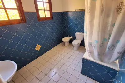 a blue tiled bathroom with a toilet and a sink at T4 Furesta - Casa Mattea in Aléria