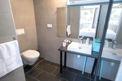 a bathroom with a toilet and a sink and a mirror at Hotel L'Escale in Porto Pollo