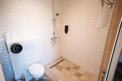 a bathroom with a shower stall with a toilet at Hotel L'Escale in Porto Pollo