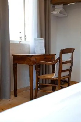 a wooden desk with a chair next to a window at Hotel L'Escale in Porto Pollo