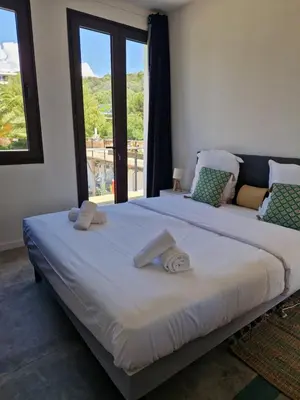 a large bed with two towels on top of it at Hotel L'Escale in Porto Pollo