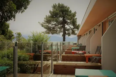a house with a balcony with a tree in the background at Hotel L'Escale in Porto Pollo
