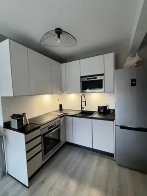 a kitchen with white cabinets and a stainless steel refrigerator at Ajaccio Sanguinaires T3 proche Trottel et 150m de la mer, belle résidence in Ajaccio