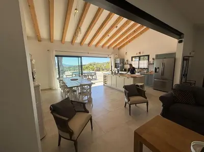 a kitchen and living room with a table and chairs at Casa Nostra in Olmeto