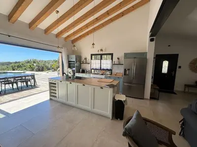 a large kitchen with a counter and a refrigerator at Casa Nostra in Olmeto