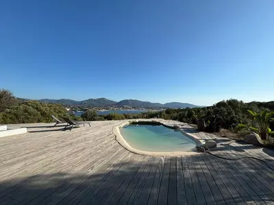 a small swimming pool on a patio with mountains in the background at Casa Nostra in Olmeto