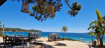 a beach with tables and chairs on the beach at Eden Cala Rossa appartement 3 chambres et grande terrasse dans résidence hotelière Fiori di Cala Rossa à Lecci in Lecci
