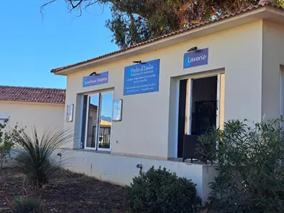 a building with blue signs on the side of it at Appartement avec piscine à 2 pas de la plage in Linguizzetta