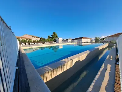 a swimming pool in a building with the sky at Appartement avec piscine à 2 pas de la plage in Linguizzetta