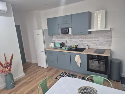 a kitchen with blue cabinets and a white refrigerator at Trottel a Livia in Ajaccio