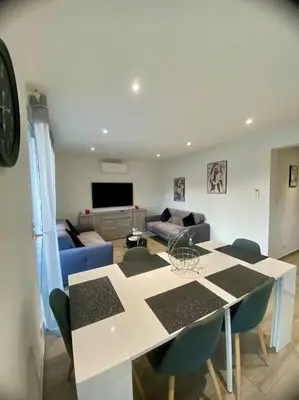 a living room with a table and a couch at Appartement F4 pour 6 personnes in Ajaccio