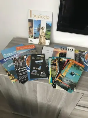 a table with a bunch of brochures on it at Appartement F4 pour 6 personnes in Ajaccio