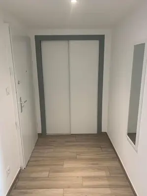 an empty room with two doors and a wooden floor at Appartement F4 pour 6 personnes in Ajaccio