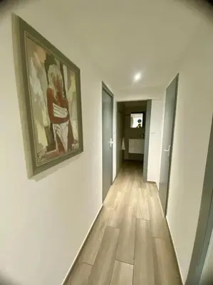 a hallway with a painting on a white wall and a hallway with a hallway at Appartement F4 pour 6 personnes in Ajaccio